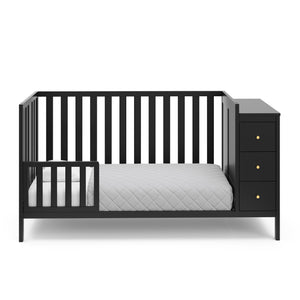 black crib with storage in toddler bed conversion with one safety guardrail