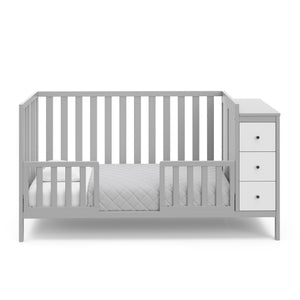 pebble gray and white crib with storage in toddler bed conversion with two safety guardrails