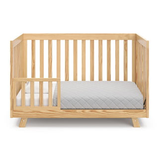 natural crib in toddler bed with one toddler safety guardrail