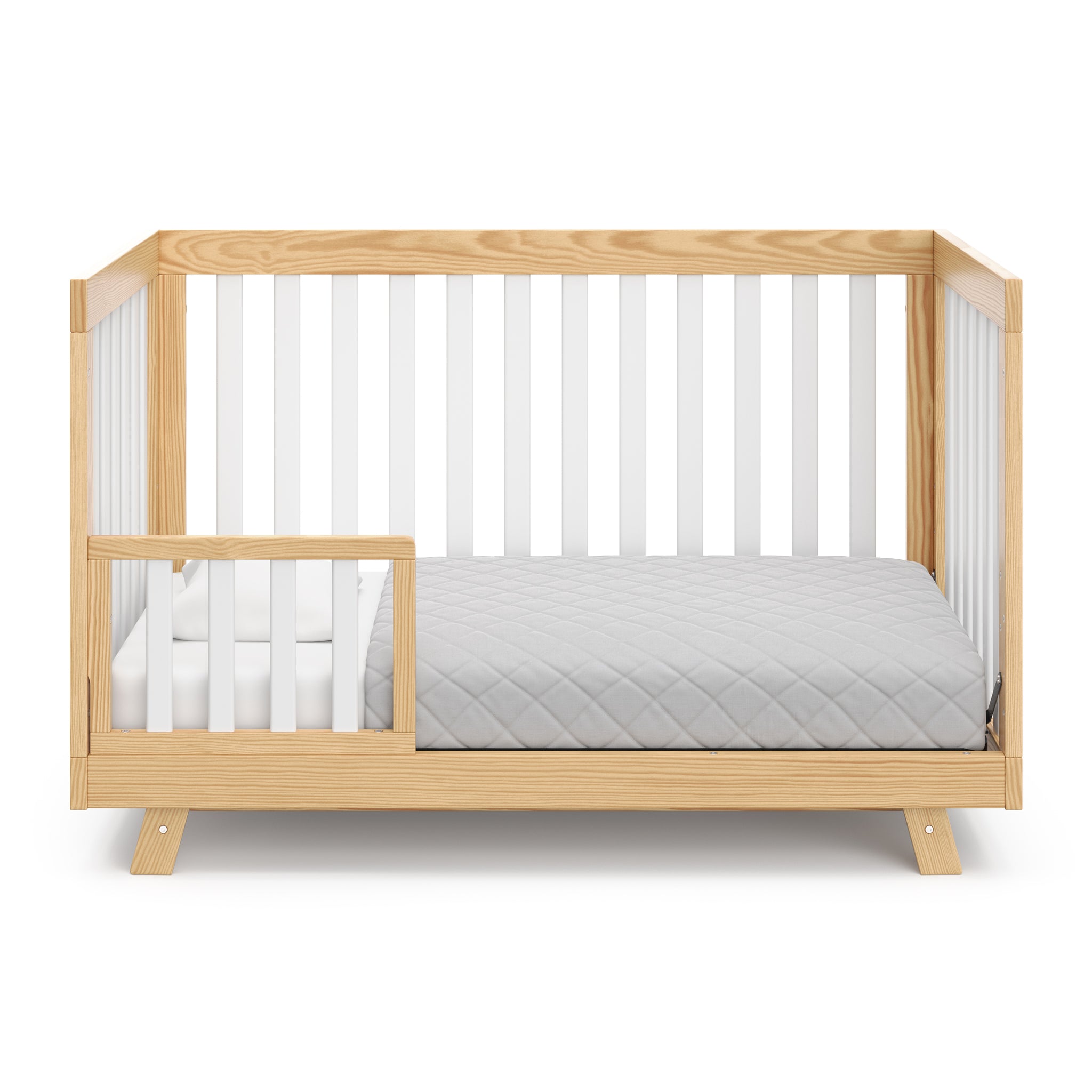Natural with white crib in toddler bed conversion with one toddler safety guardrail
