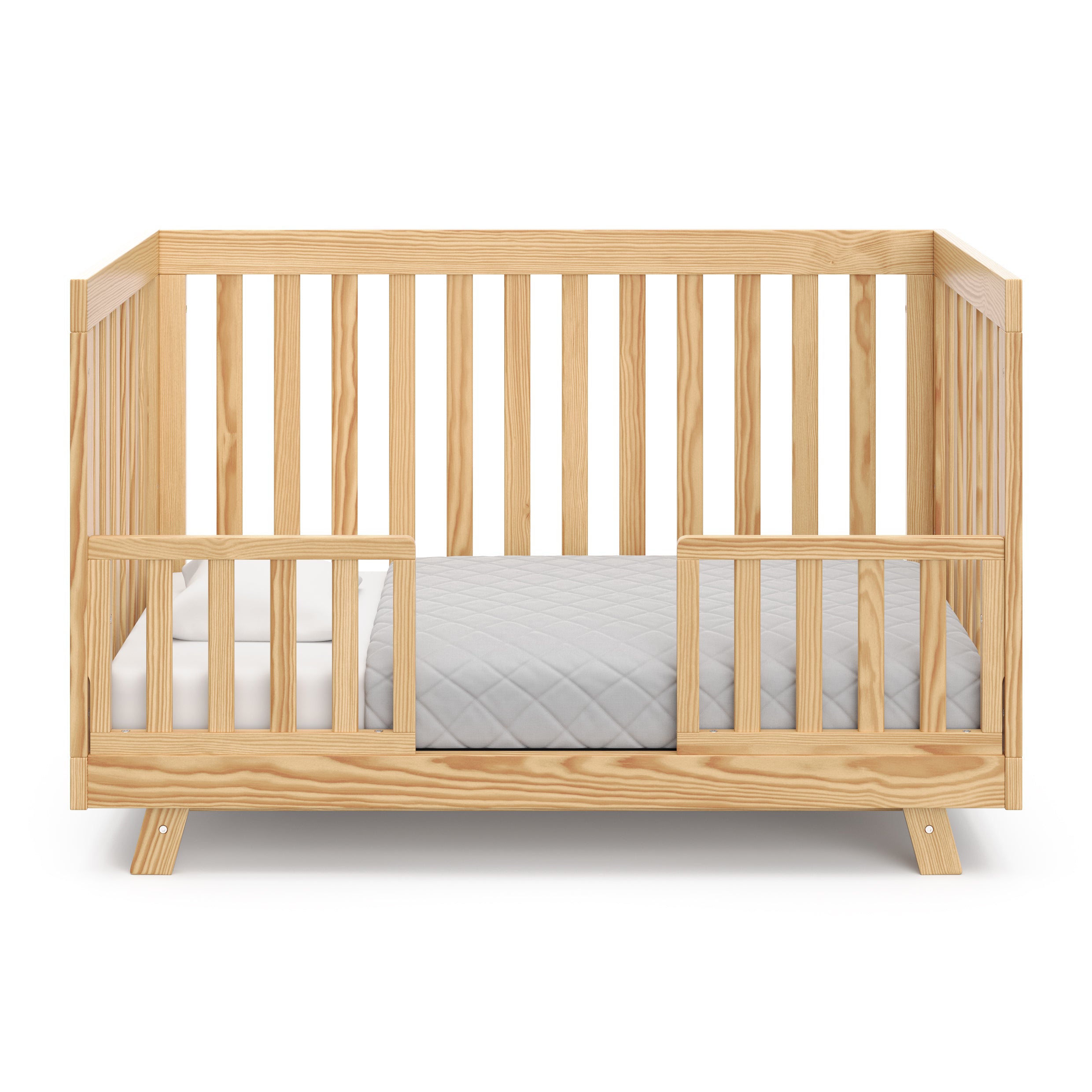 natural crib in toddler bed with two toddler safety guardrails
