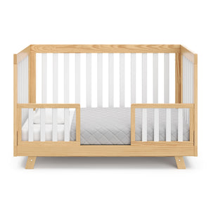 Natural with white crib in toddler bed conversion with two toddler safety guardrails