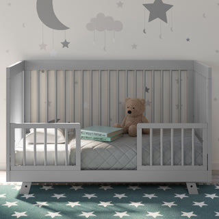 Pebble gray crib in toddler bed conversion with guardrails, in nursery