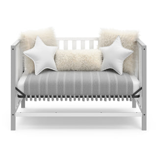 White crib with pebble gray in day bed conversion