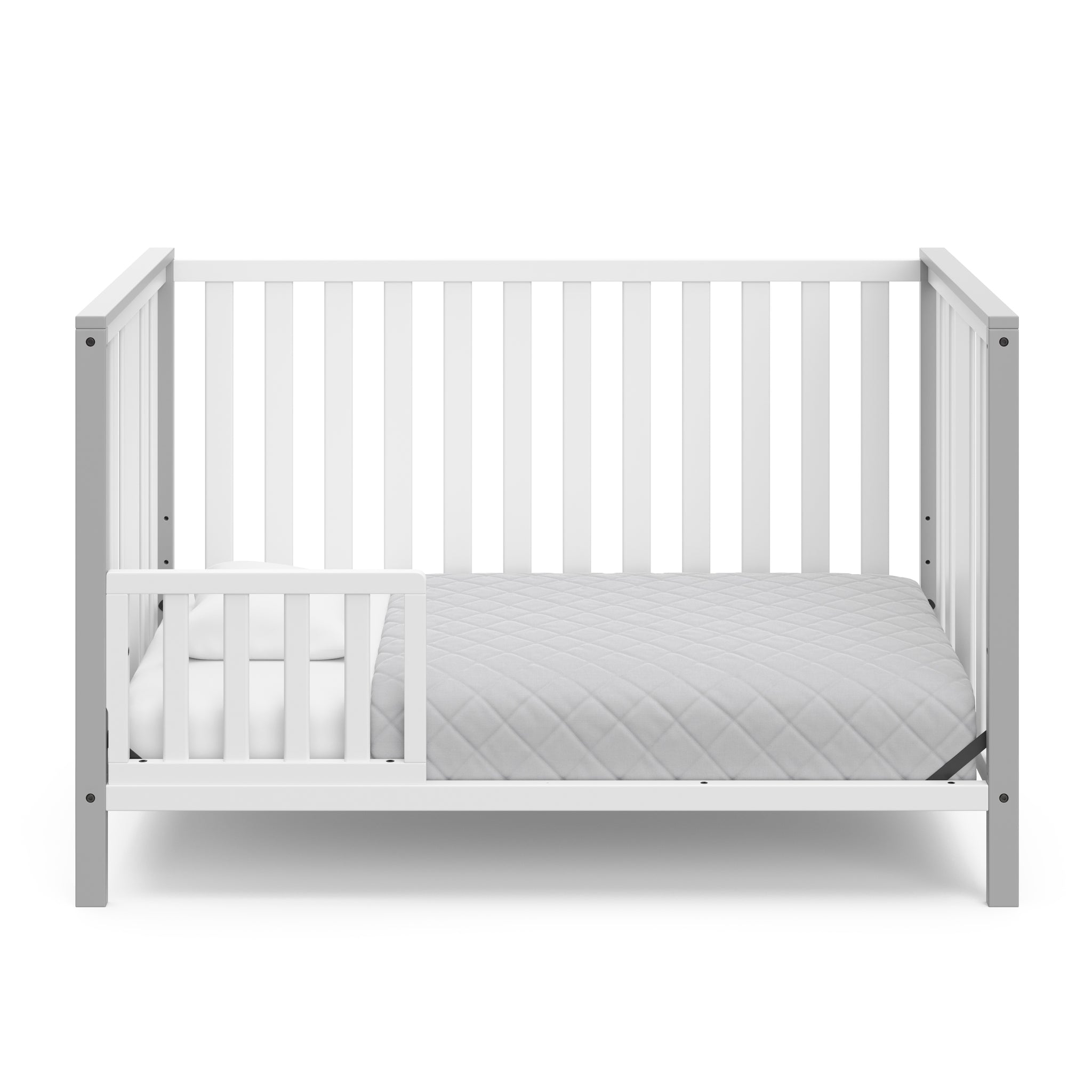 White crib with pebble gray in toddler bed conversion with one safety guardrail