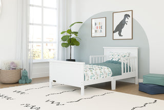 white toddler bed with guardrails in nursery