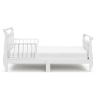 Side view of white toddler bed with guardrails