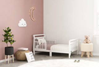 white toddler bed with guardrails in nursery