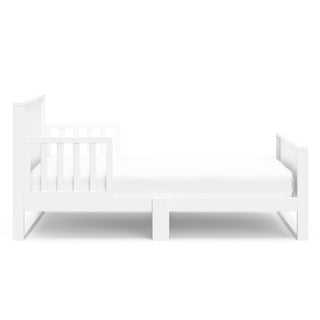 Side view of white toddler bed with guardrails 