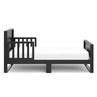 Side view of black toddler bed with guardrails 