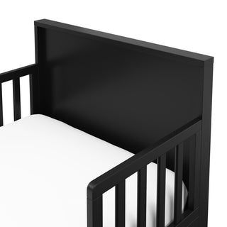 Close-up view of black toddler bed’s headboard 