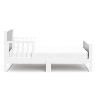 Side view of white with pebble gray toddler bed with guardrails 
