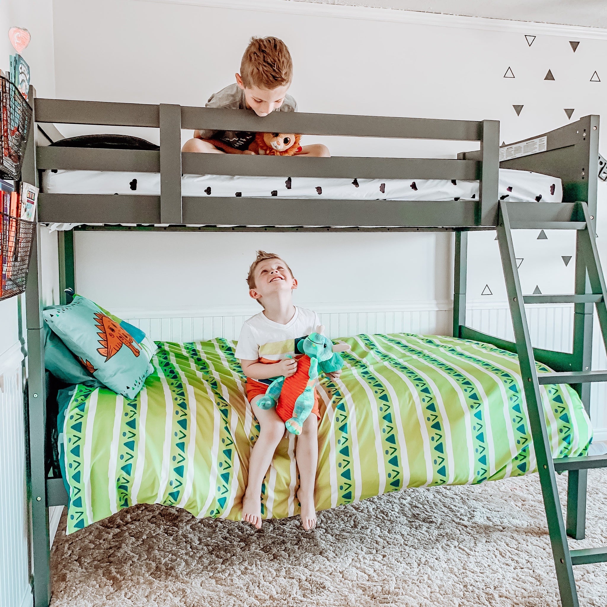 gray bunk bed with fixed ladder in nursery with children 
