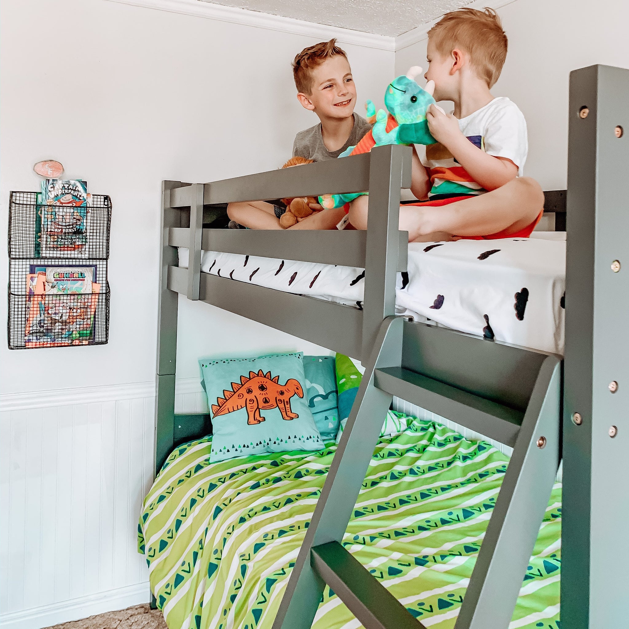 gray bunk bed with fixed ladder in nursery with children 
