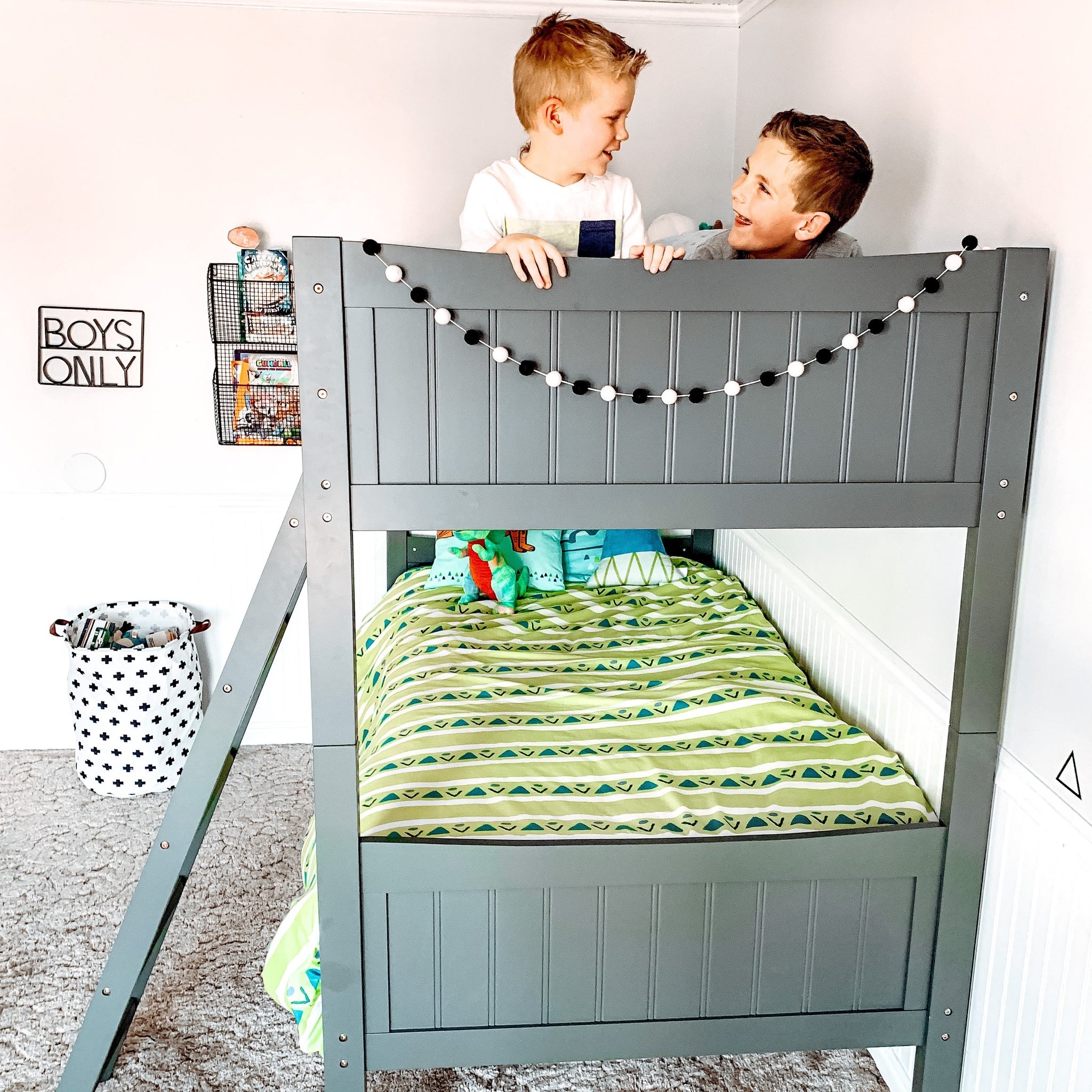 gray bunk bed with fixed ladder in nursery with children footboard view