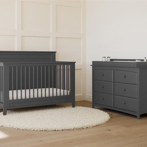 gray crib in nursery with 6 drawer dresser 