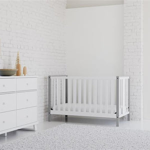 white crib with pebble gray angled in nursery with 6 drawer dresser