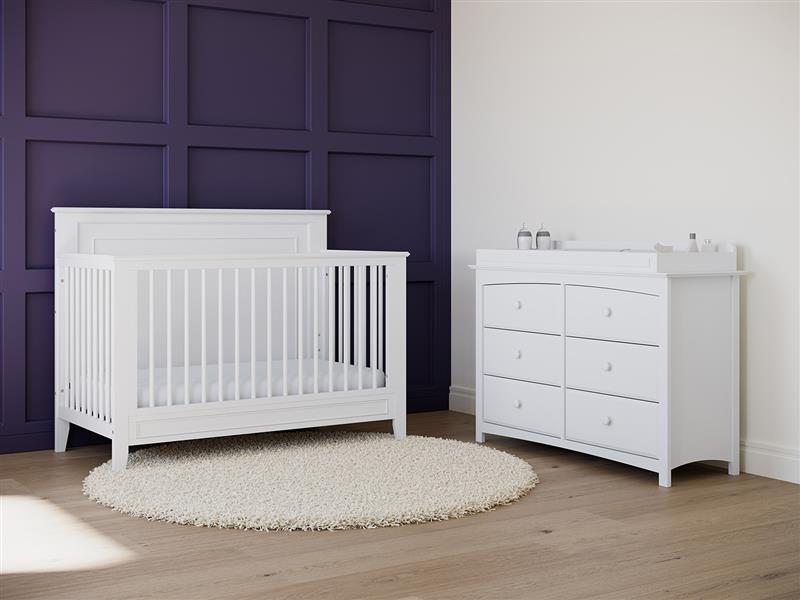 White crib in nursery with 6 drawer dresser 