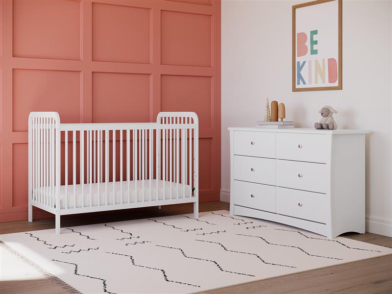 white crib in nursery with 6 drawer chest
