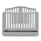 Pebble gray crib with open drawer angled