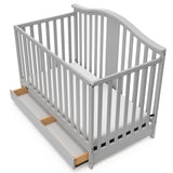 Pebble gray crib with open drawer angled