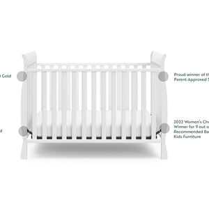 White crib angled with awards and certificates graphic