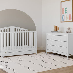 White crib with drawer in nursery