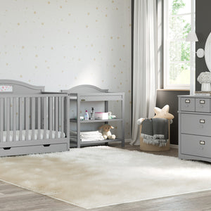 Pebble gray changing table with removable headboard and two open shelves in nursery 