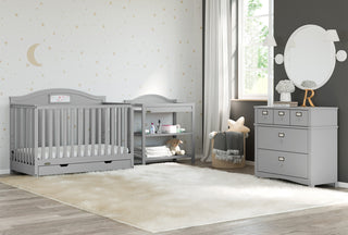 Pebble gray changing table with removable headboard and two open shelves in nursery 