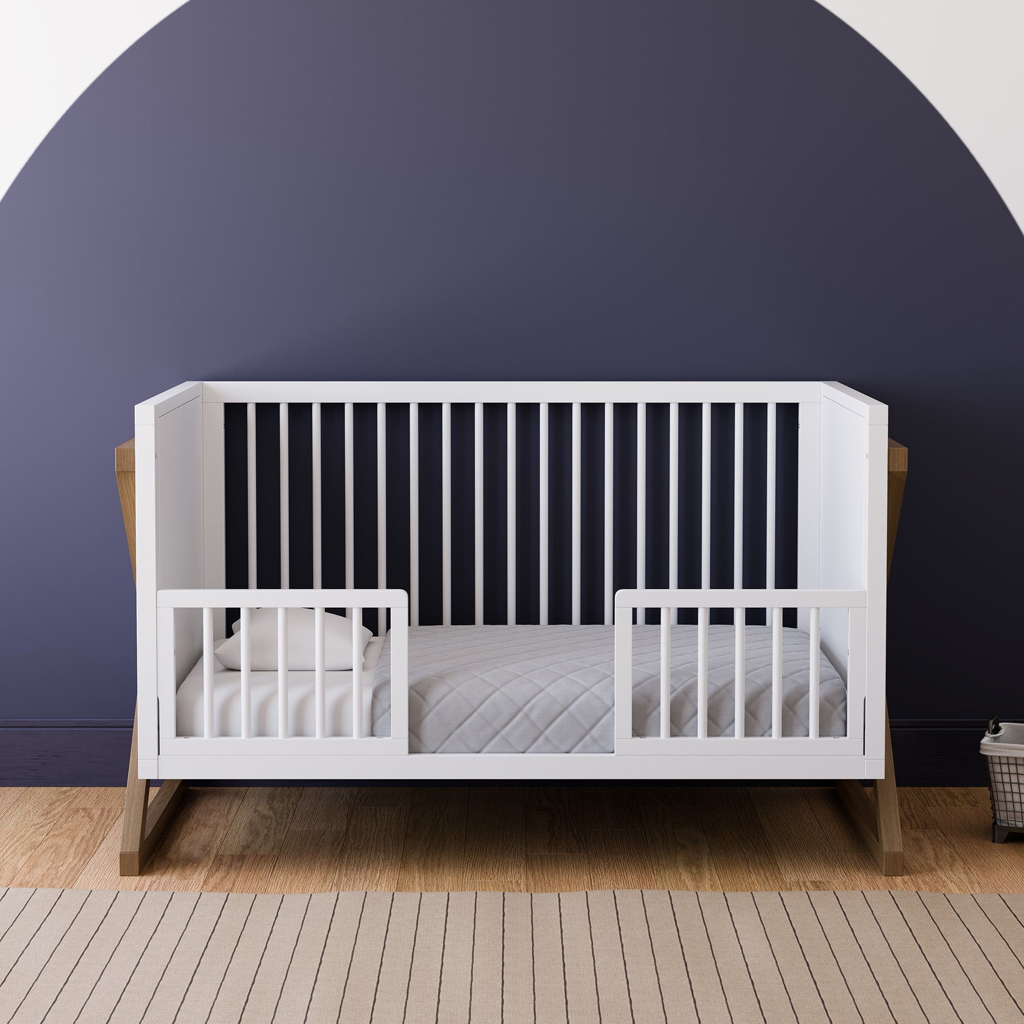 white toddler safety guardrail with dowels applied in toddler bed, in nursery