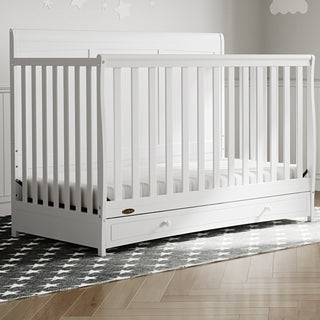 white crib with drawer in nursery