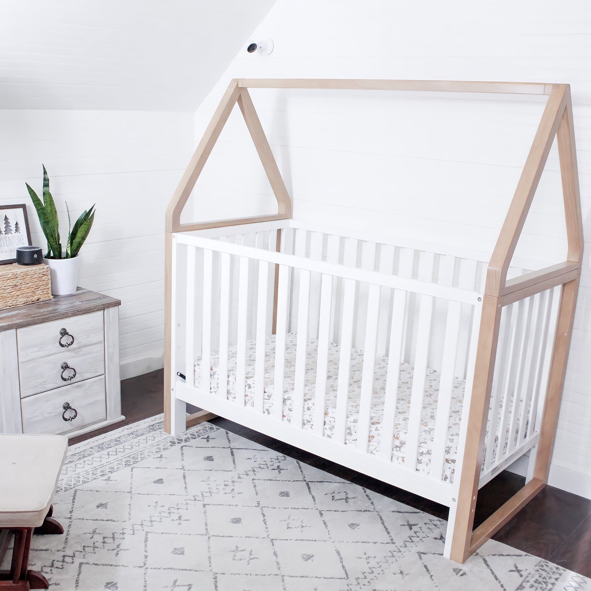 white crib with driftwood angled in nursery
