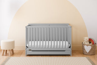 pebble gray crib with drawer in nursery