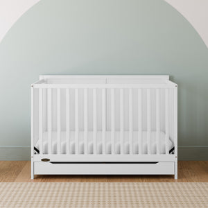 white crib with drawer in nursery
