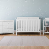 white crib, 6 drawer dresser, and changing table in nursery