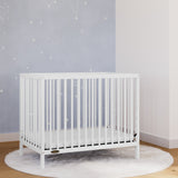 White mini crib in nursery