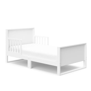 White toddler bed with guardrails angled 