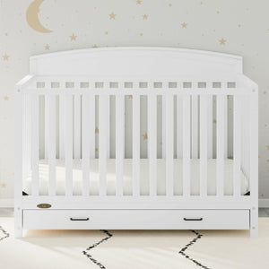 White crib with drawer in nursery