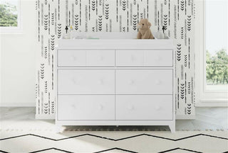 white changing topper on top of 6 drawer dresser in nursery  