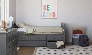 gray twin size captains bed with open twin trundle and open drawer in nursery with 6 drawer chest
