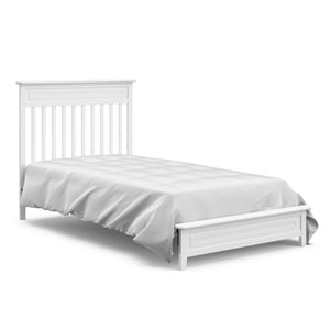 White mini crib in twin-size bed with headboard conversion 