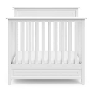Front view of white mini crib 