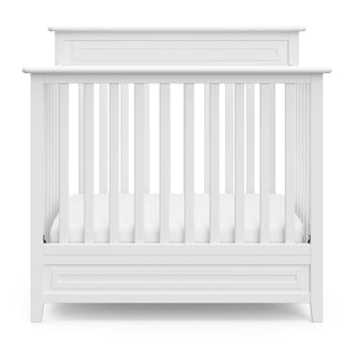 Front view of white mini crib 