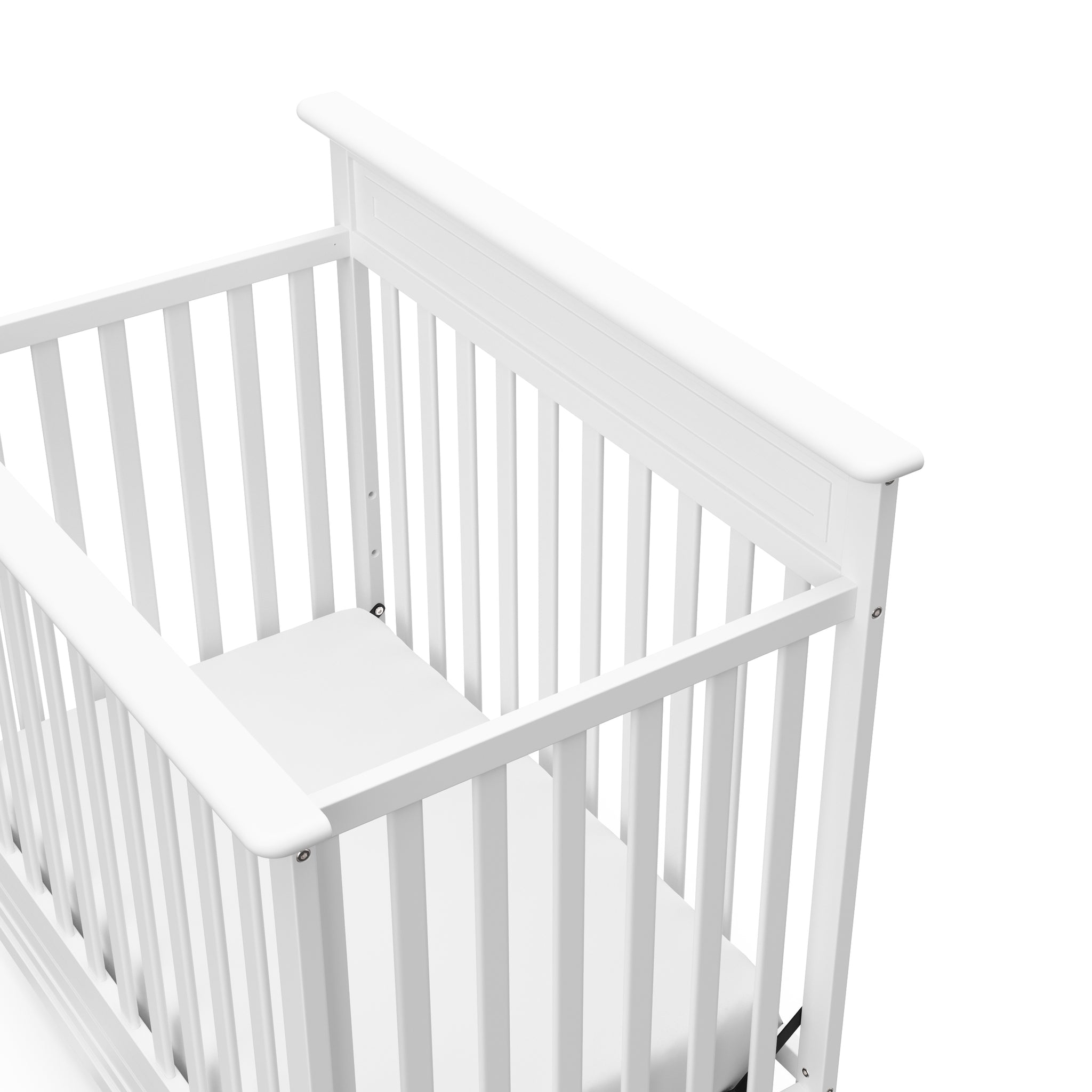 Close-up view of white mini crib's headboard 