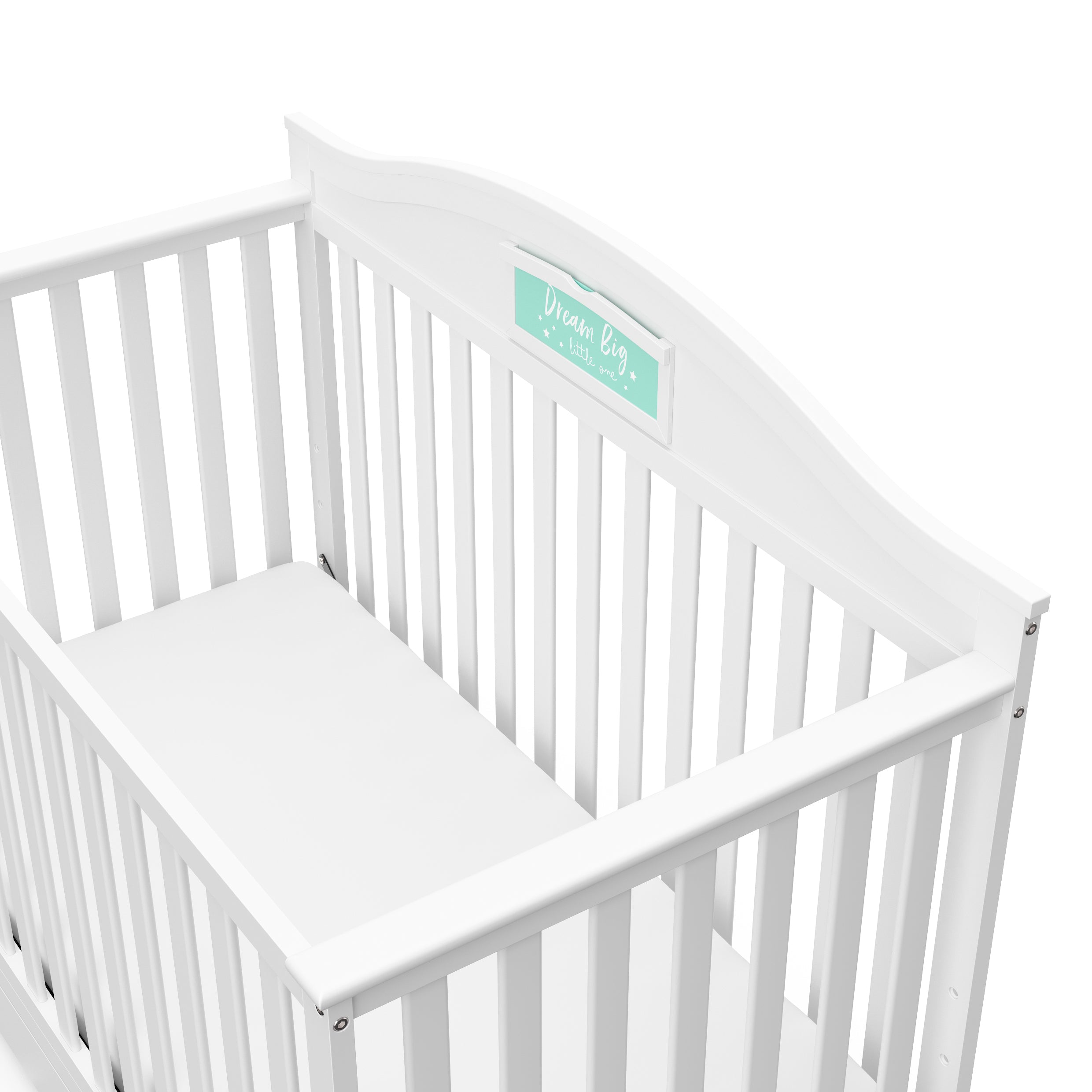 Close-up view of white crib with drawer