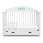 White crib with drawer in toddler bed conversion with one safety guardrail